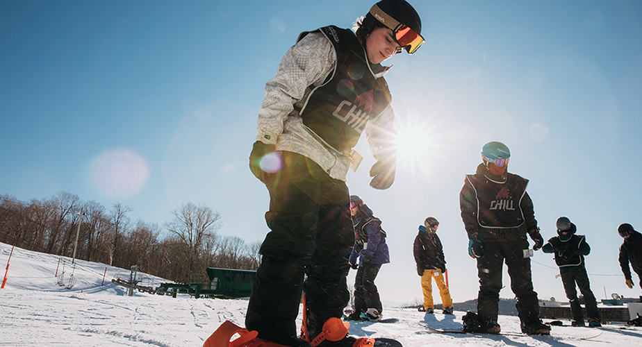 Chill youth getting ready to snowboard.