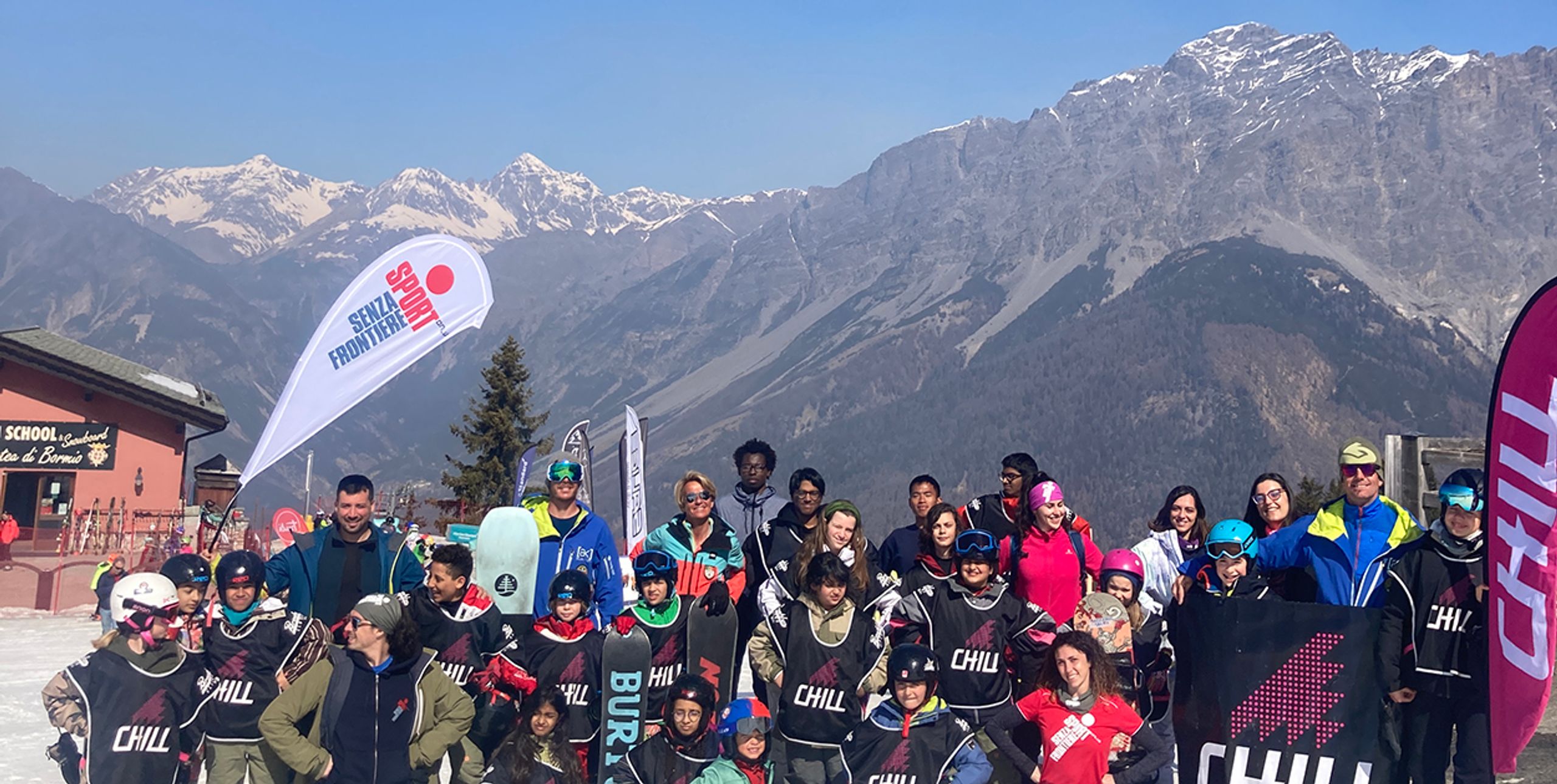 Group photo of Chill Italy participants ontop of a mountain with Chill wind-flags