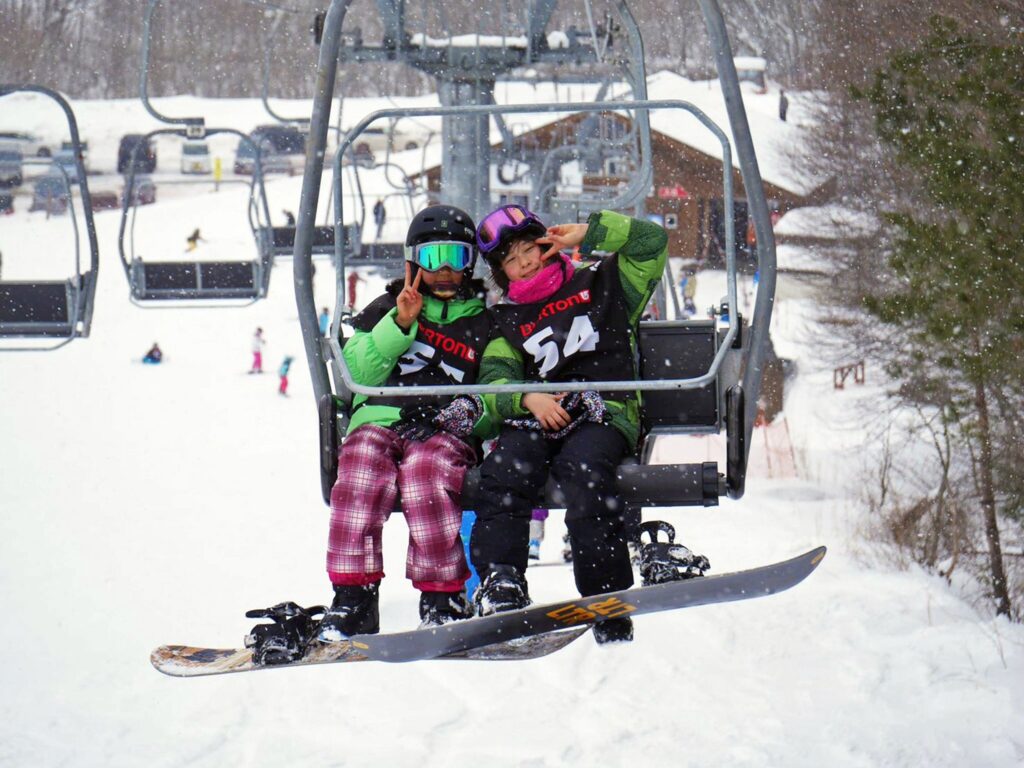 Chill youth smiling and throwing peace signs from the chairlift